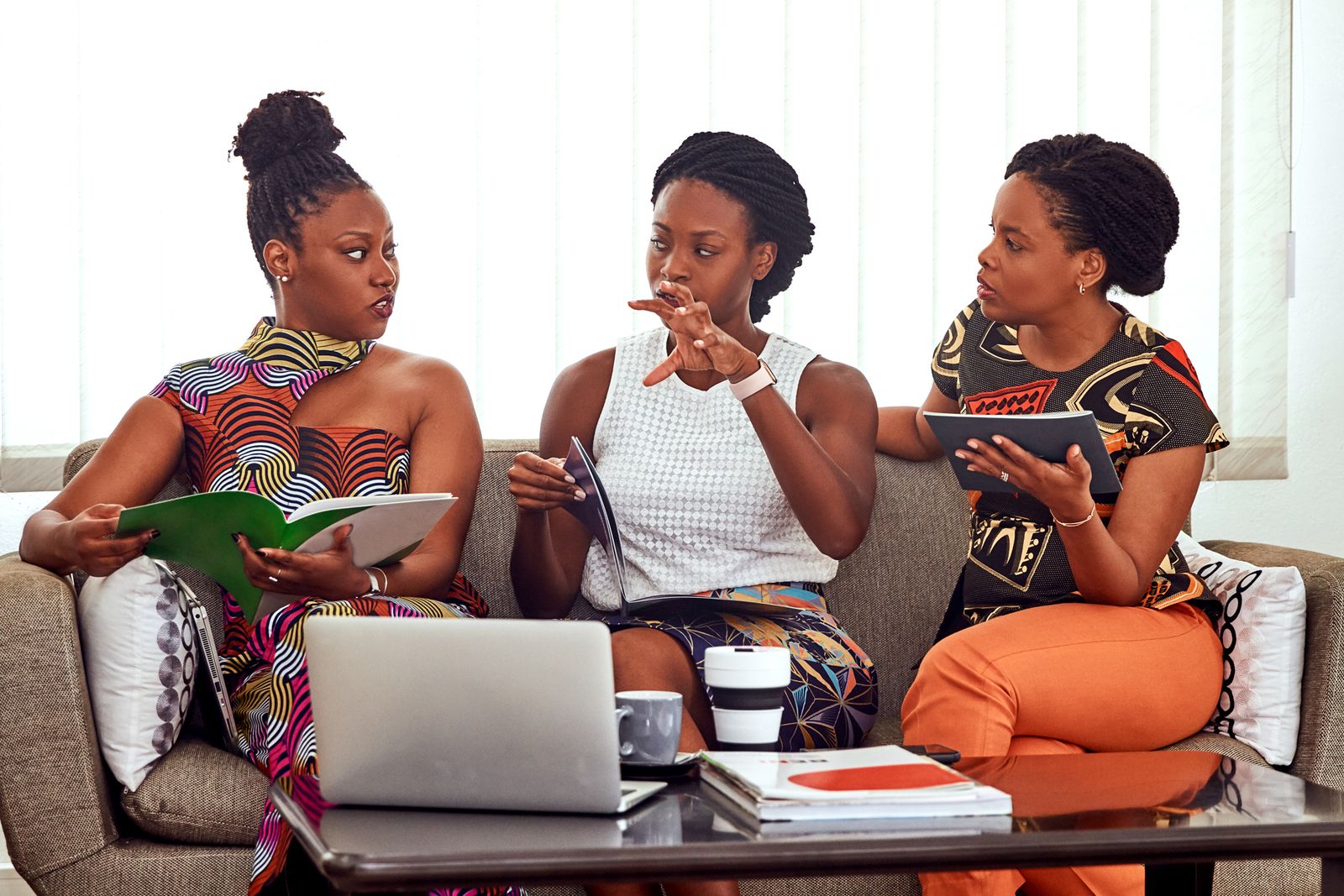Three women in collaborative conversation around a table