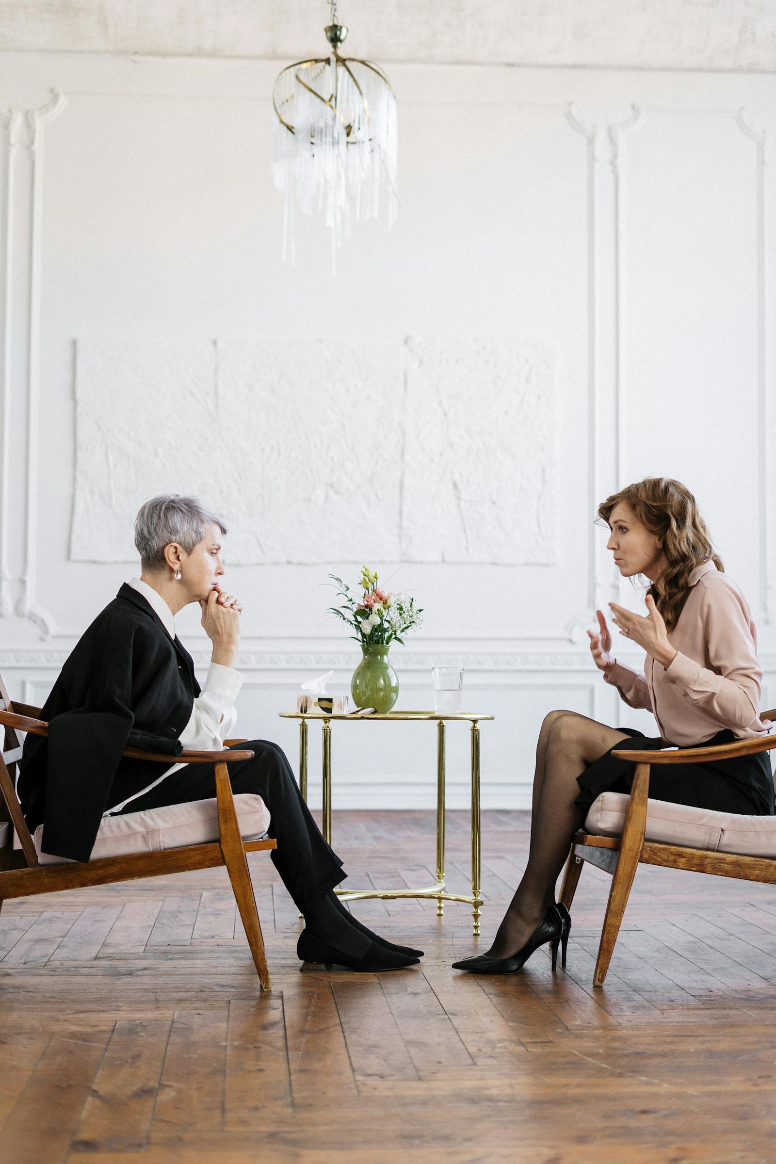 Two women in warm conversation in a bright, calm room